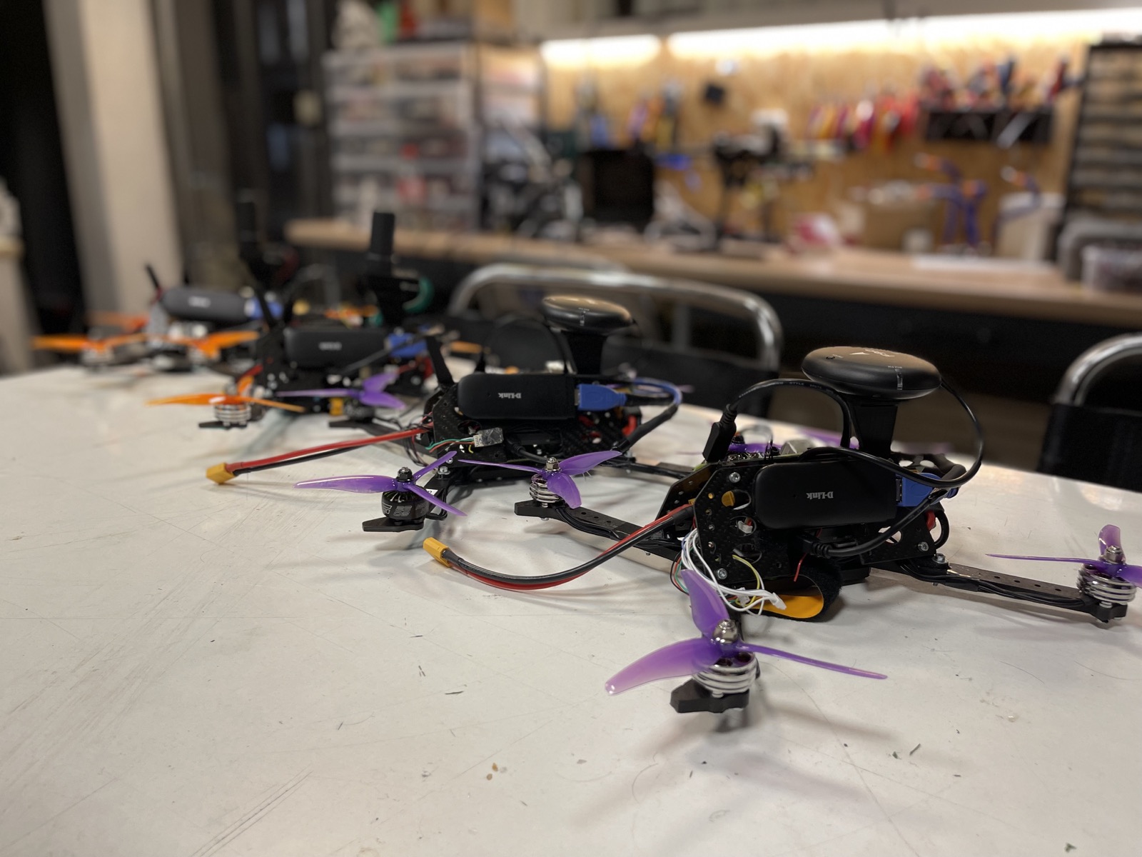 ADDI's custom-built quadcopters lined up on a workshop table